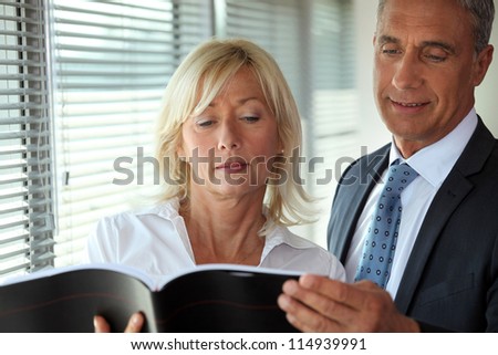 Senior business couple reading through document