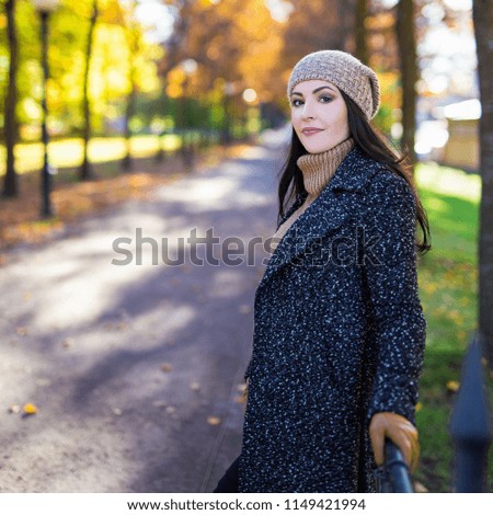 portrait of attractive woman posing in autumn park
