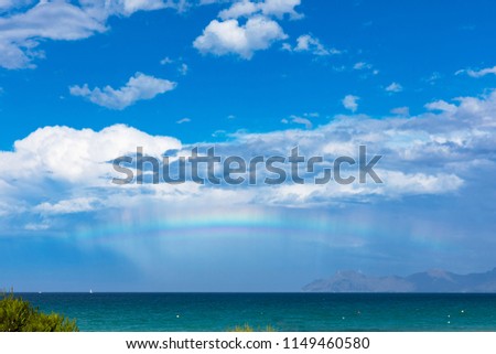 Rainbow over the mediterranean sea on Mallorca / Still raining and sun from the back that an rainbow occurred at the horizon
