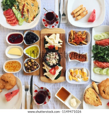 Breakfasts are usually rich in Turkish cuisine and include a lot of varieties; here in the photo there is butter, green and black olives, different jams, honey, cheese varieties, boiled eggs etc Royalty-Free Stock Photo #1149471026