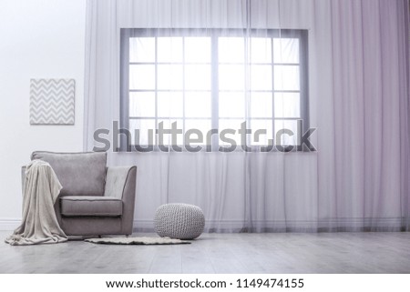 Stylish comfortable armchair near window