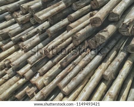 round wood cut for construction material usage. worn rough wood in a heap stack pile