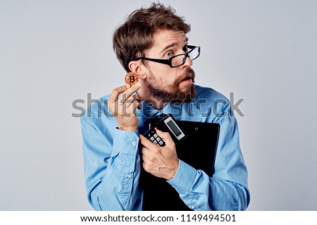  A man in glasses holds the documents and Bitcoin hands.                              