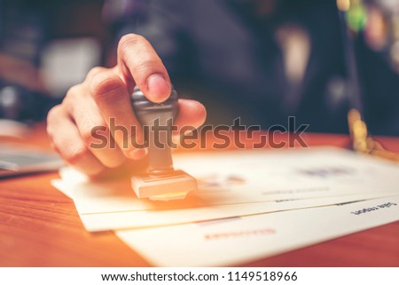 Close-up hand stamping of businessman for signing approval on documents , business concept Royalty-Free Stock Photo #1149518966