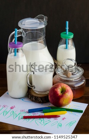 Milk,honey,apple and oil pastel painting a picture on the wooden table.School time.Vertical image