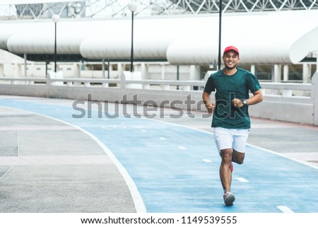 Young asian man running in the urban city with copy space. Fitness, workout, sport, lifestyle concept. Royalty-Free Stock Photo #1149539555