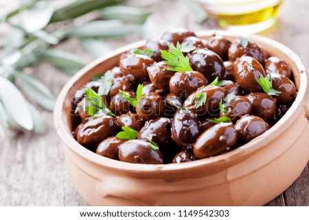 Bowl of black olives with fresh herbs