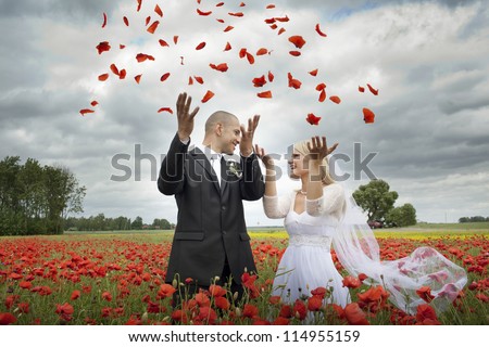 Newlyweds in blooming poppy fields, throwing petals overhead.
