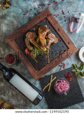 grilled lamb ribs with sauce, vegetables and a bottle of wine