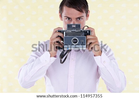 Retro styled man holding a medium format old style camera
