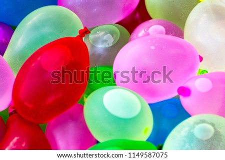 Many bright and colorful water balloons close up.