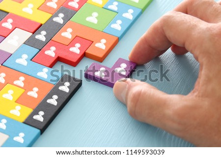 image of tangram puzzle blocks with people icons over wooden table ,human resources and management concept Royalty-Free Stock Photo #1149593039