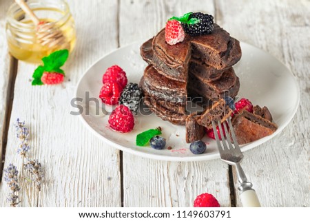 chocolate pancakes with fresh berries, honey and mint