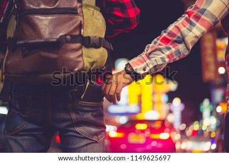 Man who stole the Backpacker tourist  cash. Hand that stealing money from the back pocket of the trousers. Warning - thieves and pickpocket in the night city. Royalty-Free Stock Photo #1149625697