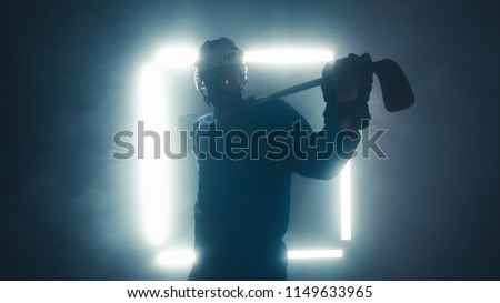 Portrait of Caucasian male ice hockey player in uniform, looking into the camera, dramatic lighting Royalty-Free Stock Photo #1149633965