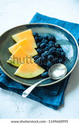 Summer fruit dessert with melon and blueberry on rustic background with copy space