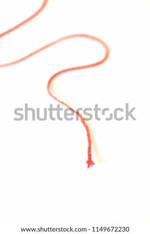 The German phrase "the thread of a story" abstractly depicted as a picture with a red thread in front of a white background - represents the inner consistency of a story