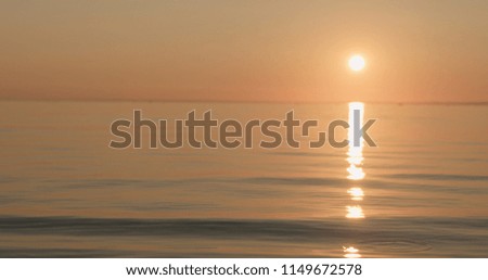 small waves on a beach at sunset