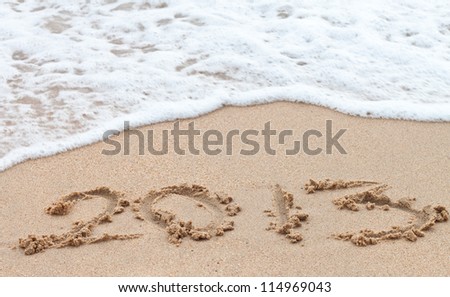 2013 year on sand background and foam of the waves. Royalty-Free Stock Photo #114969043