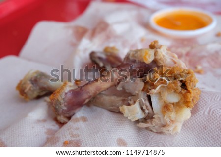 Picture of chicken bone on tissue paper after finishing. After meal of Fried chicken. Prohibited food for dogs.