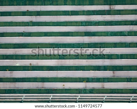 old green and white concreat sport seat grandstand outdoor and fence in an empty stadium. 