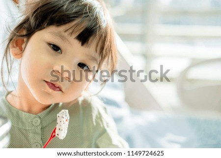 little asian girl eating dragon fruit.