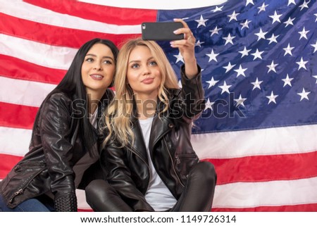 cherming female sport fans are taking selfie in front of the flag. copy space. close up photo