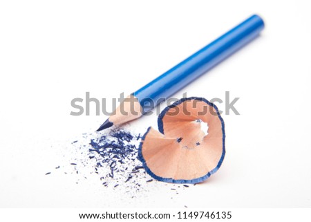 Blue colored pencil with shavings and gratings (dust or fragments) on a white background. 