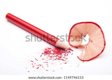 Red colored pencil with shavings and gratings (dust or fragments) on a white background