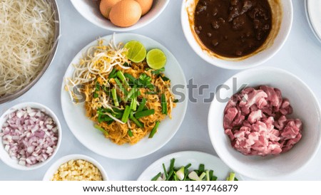 Padthai or Thai style fried noodle with its ingradient on the white table. Picture is partly focus and in flat layout.