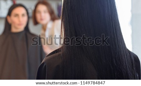 Female barber showing woman her new hairstyle. focus is only hair