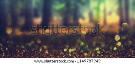 Abstract photo of light burst among trees and glitter bokeh.Image is blurred