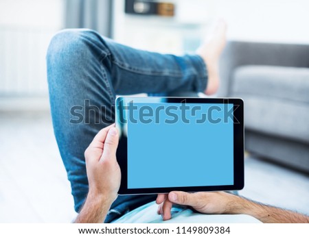 Man Using Tablet PC While Lying on a Floor. View from above. Clipping path included.