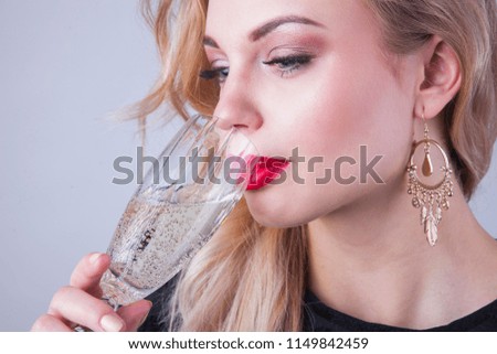 Beautiful blonde woman celebrating her birthday with glass of champagne.	