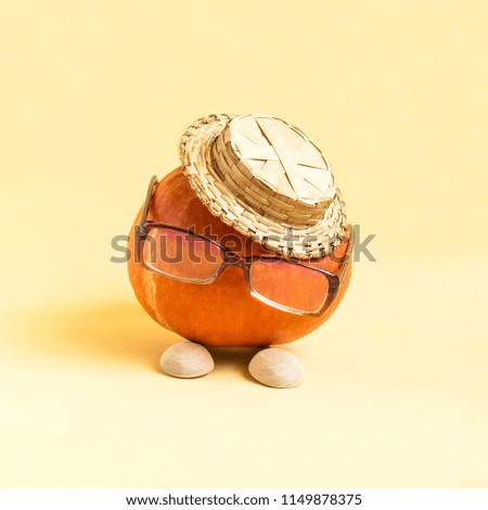 Pumpkin in form of funny little man in hat and glasses, wooden spoons instead of legs. Minimal style. Creative idea, imagination and fantasy. Original concept of Thanksgiving and other autumn holidays