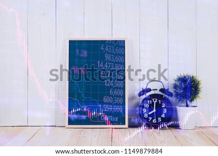 Double exposure of alarm clock with green chalkboard, financial graph, with candle stick and stock market screen, business planning vision and finance analysis concept.