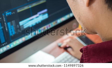 Male Videographer Edits and Cuts Footage and Sound on His Personal Computer.Shift focus