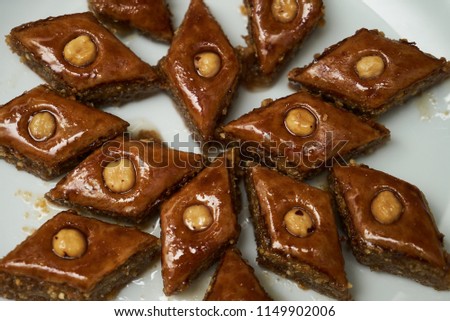 Traditional Azerbaijan dessert baklava with walnuts and cardamom on white plate. Homemade baklava with nuts and honey.