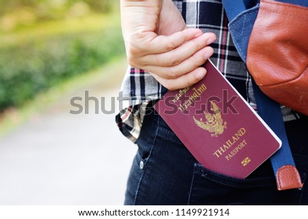 Young tourists Hand picking up a passport of Thailand and copy space