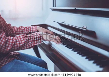 Close up of young pianist's hands playing on the piano keys