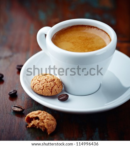 Cup of espresso and biscotti. Cup of coffee with a sweet cookie and coffee beans. Symbolic image. Rustick wooden background. Close up. 
 Royalty-Free Stock Photo #114996436
