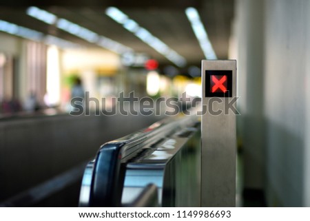 Slide walk in an airport with red cross sign