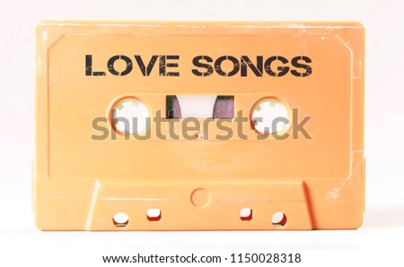 A vintage cassette tape from the 1980s era (obsolete music technology) with the text Love Songs printed over it (my addition, not in the original image). Color: cream, sand. White background.
