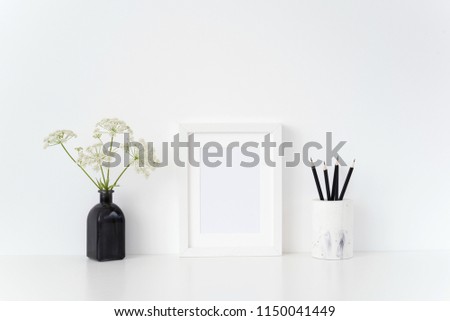 Stylish summer white portrait a5 frame mock up with a Aegopodium in black vase and black pencils on white background. Mockup for quote, promotion, headline, design.