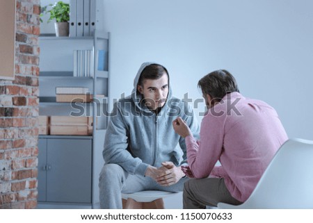 A psychology specialist explaining an action plan for recovery to a troubled teenage boy during an individual therapy session. Royalty-Free Stock Photo #1150070633