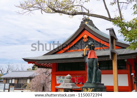 The view of fox statue and red pavilion of Fushimi Inari Taisha famous temple in Kyoto Japan