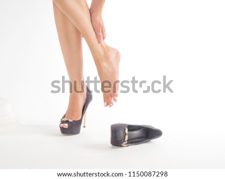 Close up photo on white background: female feet in pain after wearing high heeled shoes.