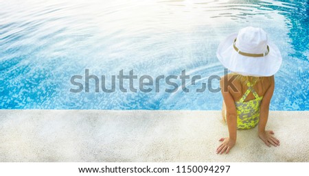 Adorable little girl having fun in outdoor swimming pool on summer vacation