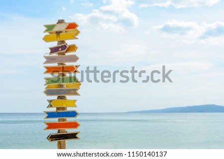 Multiple blank signs on a wooden pole in the beach.place for text
