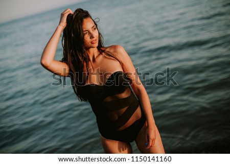 Pretty young woman at sea on a sunset